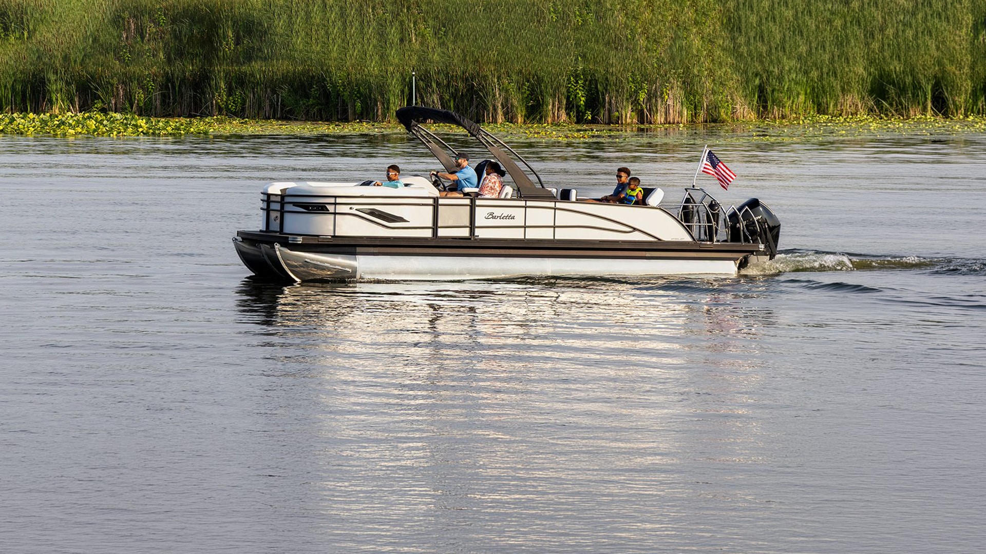 Family cruising on a Barletta pontoon in early fall