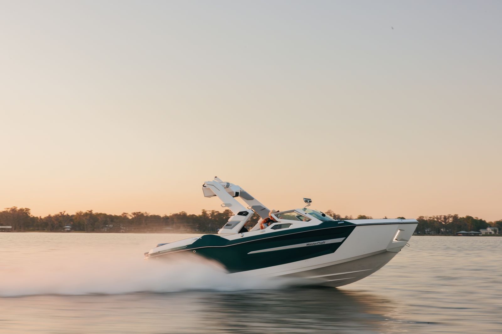 MasterCraft running across a lake at sunset